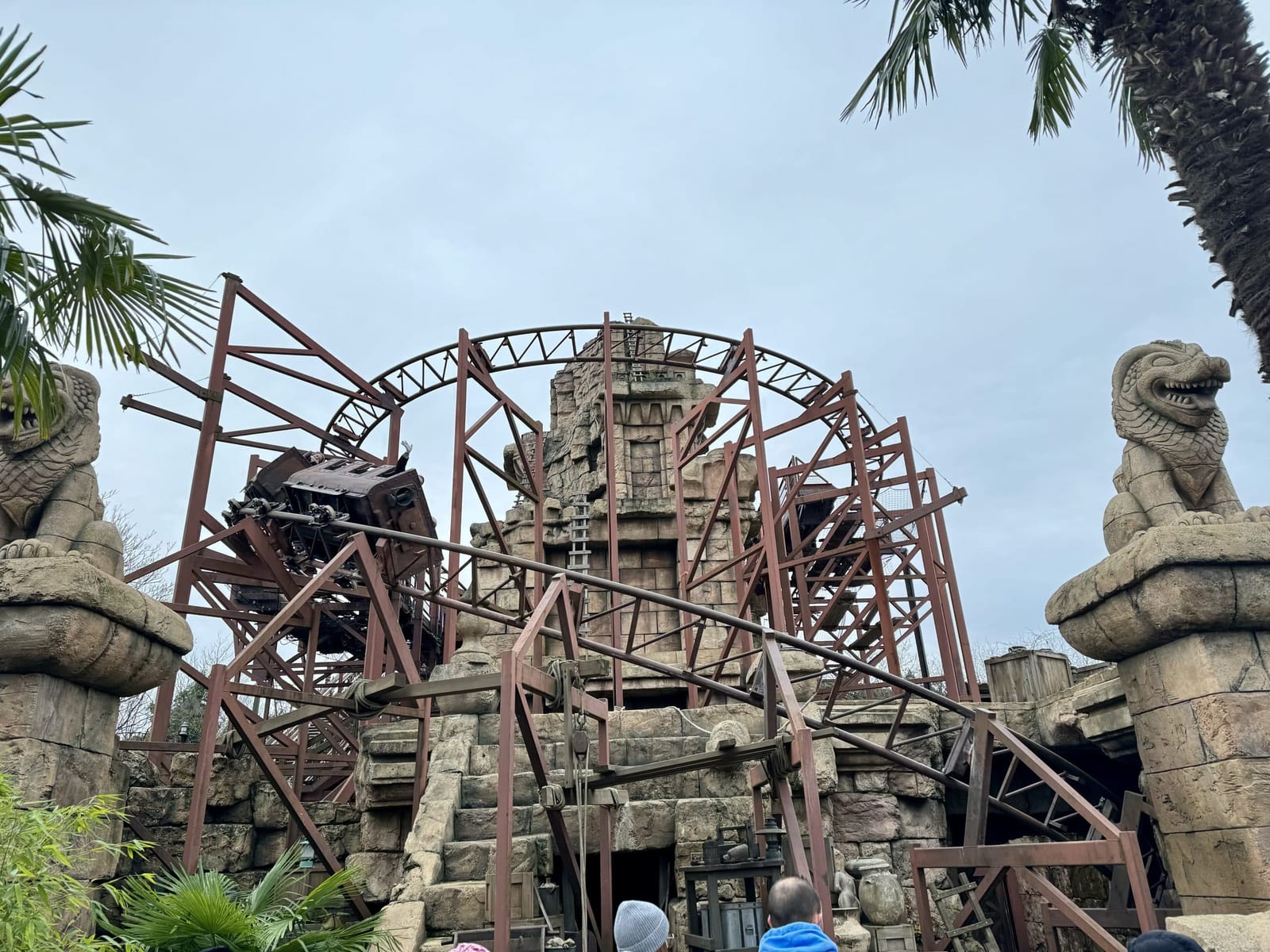 Montagne russe Indiana Jones et le Temple du Péril dans Adventureland, wagons de mine passant sous un looping entouré de végétation tropicale et de ruines de temple