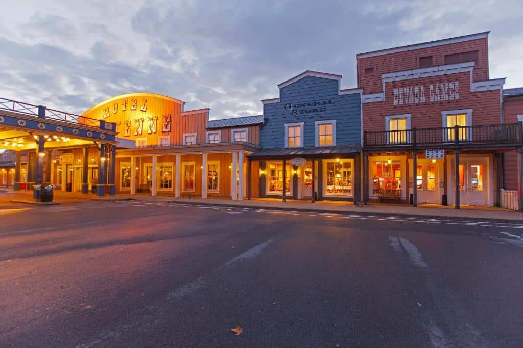 Façade de l'hôtel Disney Hotel Cheyenne à Disneyland Paris, rue en sable du Far West avec bâtiments en bois peint et enseignes Western