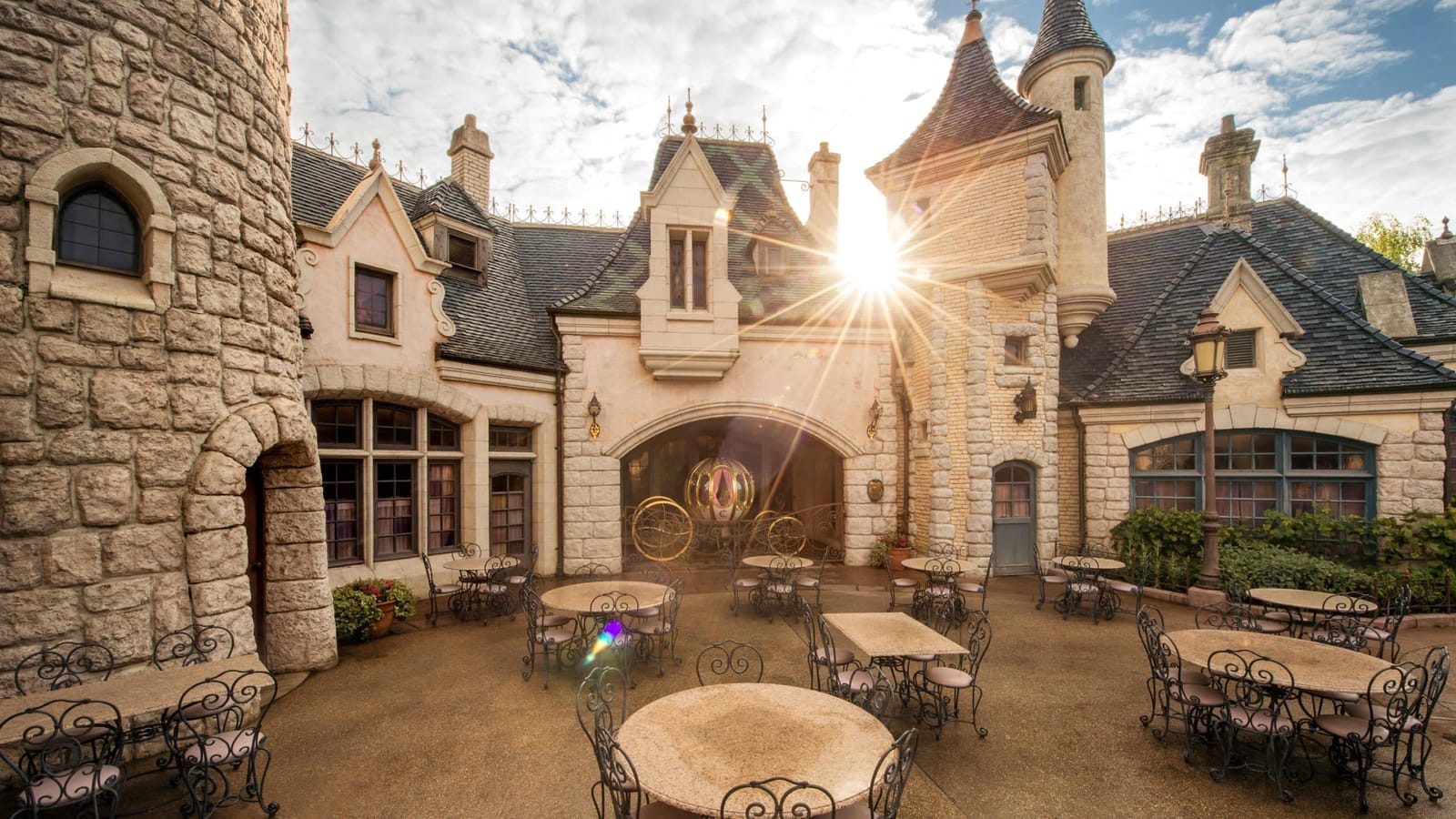 Façade de L'Auberge de Cendrillon à Fantasyland, bâtiment de style château médiéval avec tourelles et vitraux en face du Carrousel de Lancelot