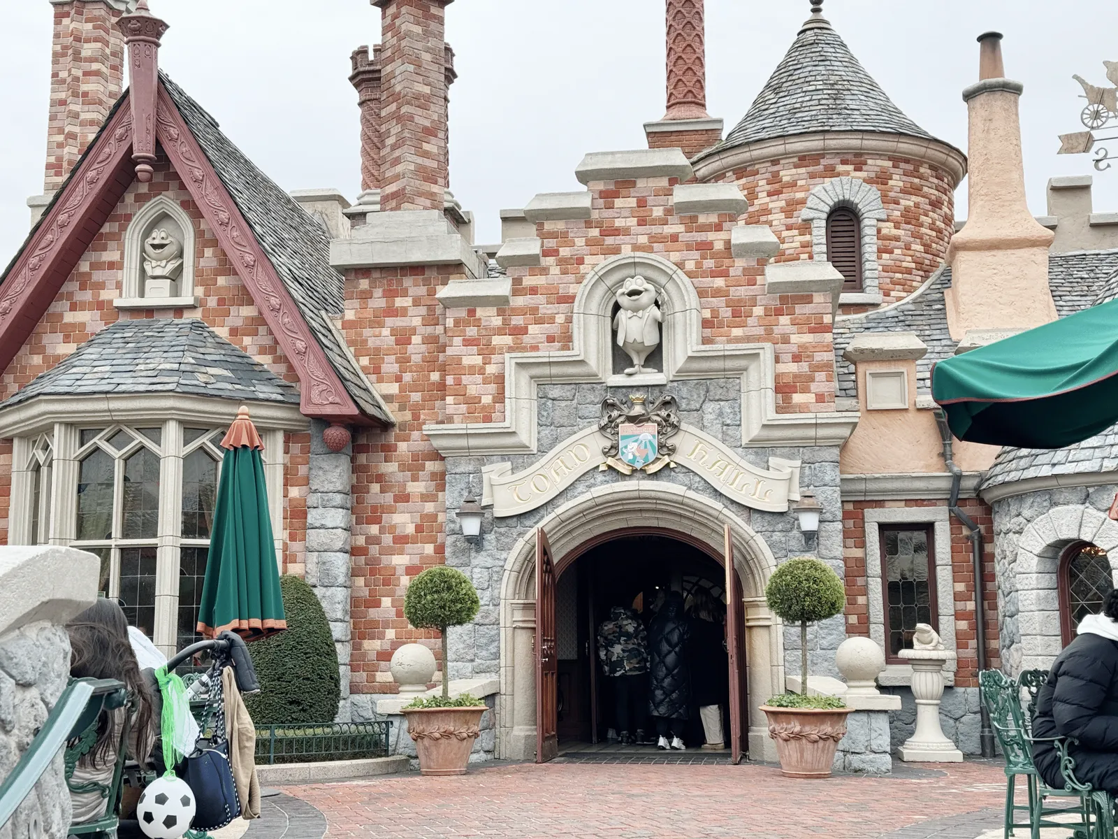 Façade du Toad Hall Restaurant à Fantasyland, bâtiment de style Tudor avec briques, cheminées torsadées et girouette représentant M. Crapaud